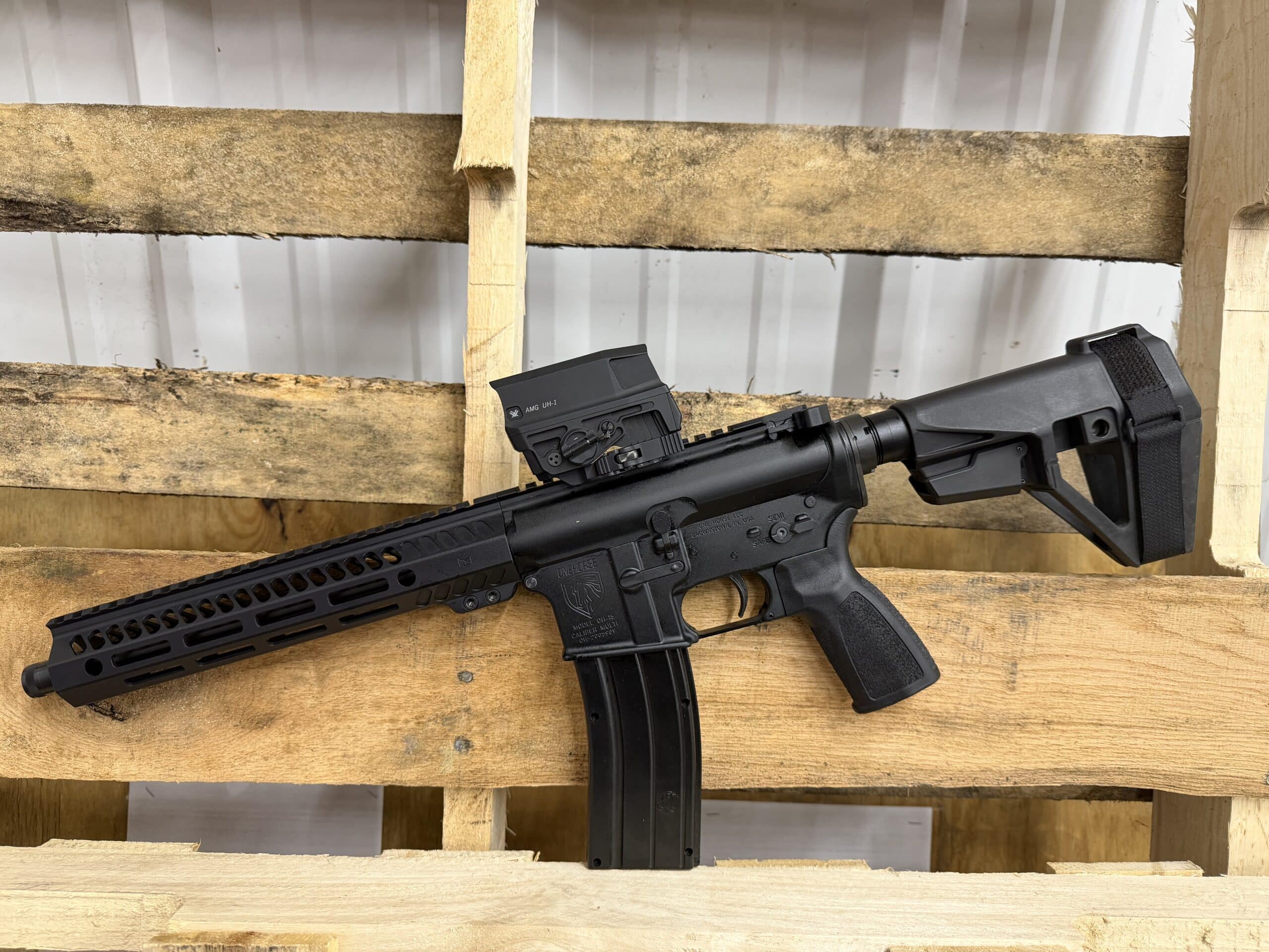 A black American-made One Horse rifle with a Vortex AMG UH-1 holographic sight, featuring a modular handguard and a tactical pistol brace.