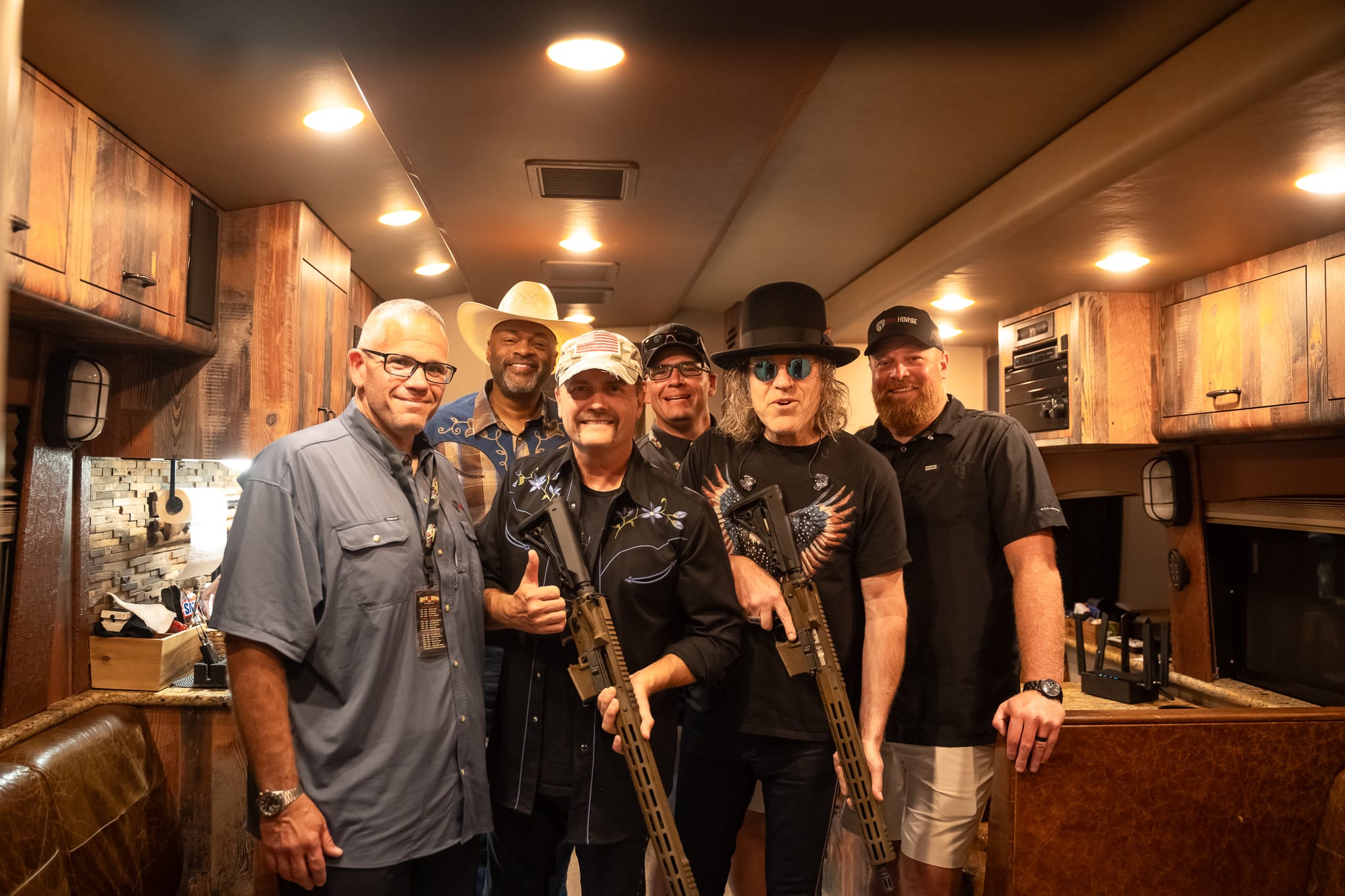 A group of men inside a rustic vehicle holding high-quality, American-made rifles, showcasing reliable craftsmanship and firearm enthusiasm.