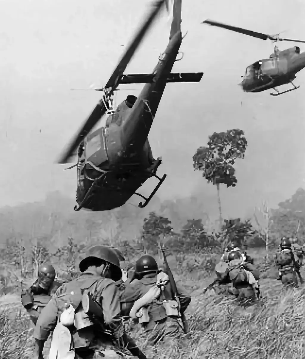 Huey helicopters landing troops in tall grass