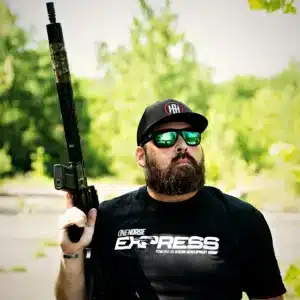 Man wearing the black One Horse Express t-shirt outdoors with a rifle